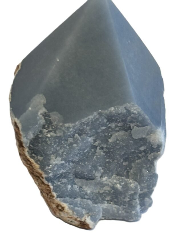 Natural rough angelite freeform with polished point 2 sians emporium Natural rough angelite freeform crystal with unpolished sides and a smooth polished blue point standing on a white background